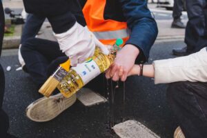 Speiseöl wird über die Hand gekippt.