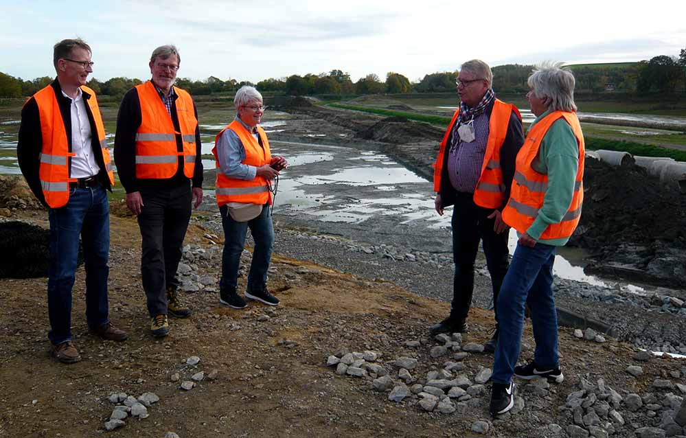 SPD-Ratsfraktion besucht das Hochwasserrückhaltebecken Ellinghausen „Das neue Hochwasserrückhaltebecken der Emschergenossenschaft in Ellinghausen wird ein weiterer Baustein zur Verbesserung des Schutzes vor extremen Wetterereignissen in Dortmund. Als SPD-Fraktion wollen wir weiter daran arbeiten, unsere Stadt noch widerstandsfähiger gegenüber Überflutung und Hochwasser zu machen“, erklärt die Sprecherin der SPD-Ratsfraktion Dortmund im zuständigen Ausschuss für Mobilität, Infrastruktur und Grün, Gudrun Heidkamp, zu dem Besuch von Mitgliedern der SPD-Ratsfraktion am Hochwasserrückhaltebecken Ellinghausen. Das Starkregenereignis im Sommer 2021 hat gezeigt, wie wichtig ein funktionierender Hochwasser- bzw. Starkregenschutz ist. Durch die Anstrengungen der Stadt Dortmund in den vergangenen Jahren konnte der Hoch- bzw. Starkregenschutz deutlich verbessert werden. Nur hierdurch kam es bei dem Starkregenereignis im Sommer 2021 nicht zu größeren Schäden auf dem Dortmunder Stadtgebiet. Mit dem vor dem Herbstferien mit den Stimmen der SPD-Fraktion im Rat der Stadt beschlossenen Handlungskonzept zur weiteren Verbesserung der Überflutungs- sowie Hochwasservorsorge und des zugehörigen Krisenmanagements in der Stadt Dortmund wird mit den einzelnen Maßnahmen das grundlegende Ziel einer wasserbewussten Stadtgestaltung verfolgt. Klar ist hierbei allerdings, dass kein vollumfänglicher Schutz für die Bevölkerung geschaffen werden kann, sondern der Fokus auf der Reduzierung des Risikos liegen muss.