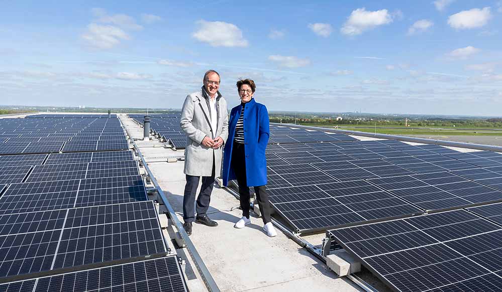 Ludger van Bebber, Geschäftsführer der Flughafen GmbH und Heike Heim, Vorsitzende der DEW21-Geschäftsführung begutachten die neue Photovoltaik-Dachflächenanlage.