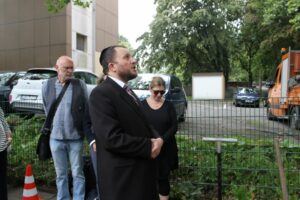 Der Rabbiner Avigdor Moshe Nosikov stellt sich vor die Stolpersteine und spricht ein Gebet.