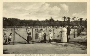 Auf dem historischen Foto sieht man eine Planschwiese: Anhand der Kleidung der spielenden Kinder kann das Bild auf die Zeit der Jahrhundertwende datiert werden. 