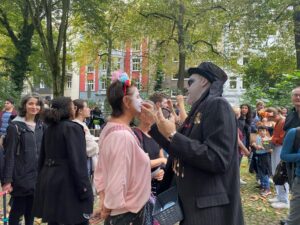 Die Besucher:innen lassen sich als Totenköpfe schminken.