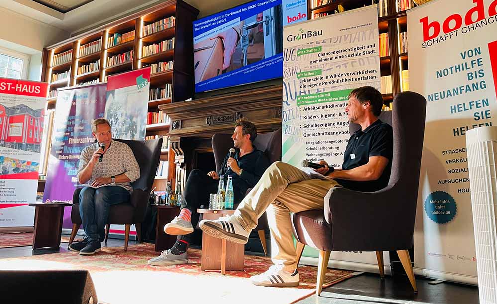 Moderator Christoph Tiegel im Gespräch mit Jan Finzi, Verantwortlicher für den Bereich Wohnungslosenhilfe beim VSE, und Timo Stascheit, Leiter der Wohnungslosenhilfe der Diakonie in Dortmund, bei der Podiumsveranstaltung im Wichern-Wohnungslosenzentrum.