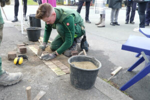 Die letzten Hammerschläge bei der Verlegung der Stolpersteine