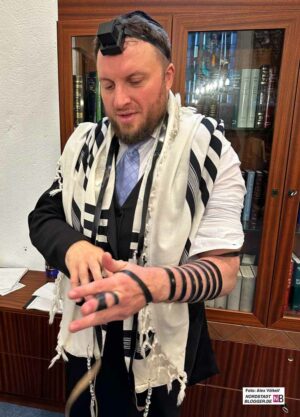 Rabbiner Avigdor Moshe Nosikov beim Anlegen der Tefillin in der Synagoge.
