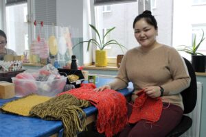 Bulganchimeg Enkhbulgan hat das Stricken bei „Einzigware“ gelernt und strickt jetzt selbstständig Schals.