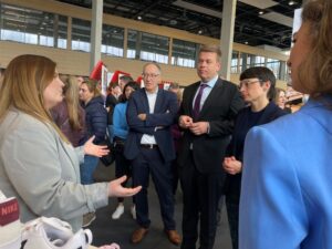 NRW-Integrationsministerin Josefine Paul, Matthias Heidmeier, Staatssekretär im Ministerium für Arbeit, Gesundheit und Soziales und Roland Schüßler, Leiter der NRW-Arbeitsagentur im Gespräch mit Vertreterin von Deichmann.