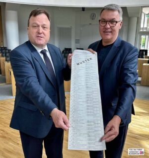 Wahlleiter Norbert Dahmen und Dortmunds OB Thomas Westphal präsentieren den Stimmzettel für die Europawahl 2024.