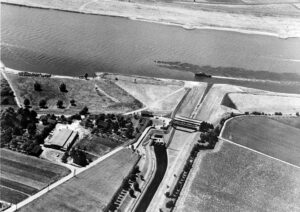 Eine Luftaufnahme der neuen Emscher-Mündung in Dinslaken aus dem Jahr 1959. Gut zu erkennen ist hier, dass die Emscher damals noch nur bei Hochwasser über das Absturzbauwerk in den Rhein stürzte. Bei Trockenwetter floss die Emscher über unterirdische Rohre direkt in den Rhein.