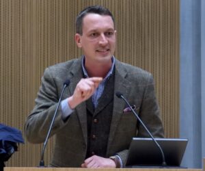 Das Motiv zeigt den Politiker bei einer Rede im Stadtrat.