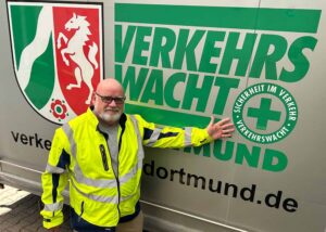 Der Vorsitzende zeigt auf das Logo der Verkehrswacht