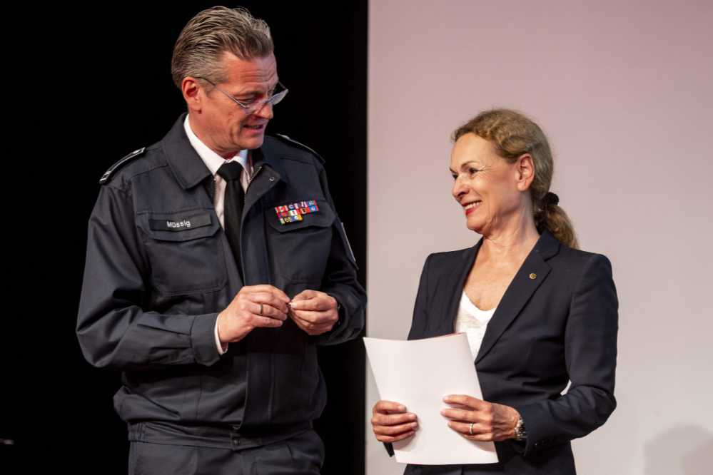 Jörg Müßig, Vorsitzender des Stadtfeuerwehrverbandes Dortmund überreicht Sabine Loos die Auszeichung in Gold.