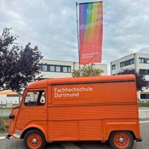 Orangenes Auto mit der Aufschrift Fachhochschule Dortmund.