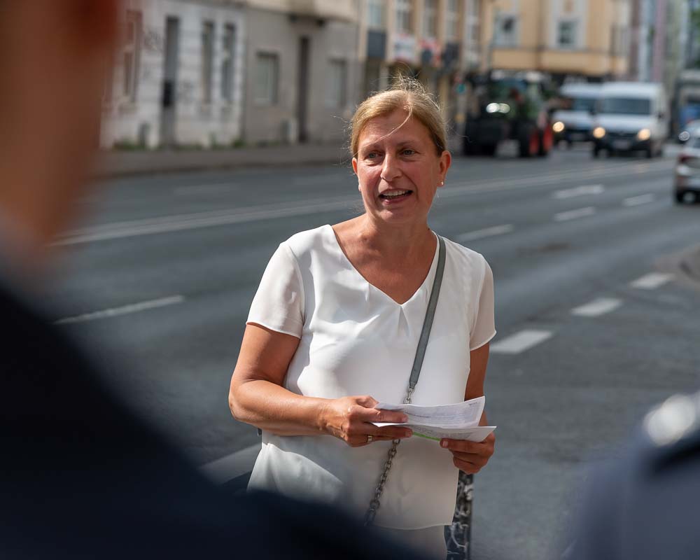 Sylvia Uehlendahl, Leiterin Tiefbauamt, im weißem T-Shirt bei der Presseaktion: Sie hält Informationsmaterial zum Thema Fahrradverkehr und Sicherheit.