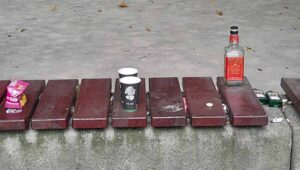 Schnapsflaschen und Becher auf einer Bank
