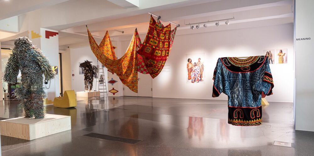 Ausstellungsansicht, afrikanische Gewänder und Modefotos