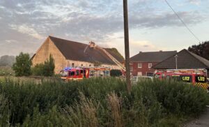 Feuerwehrfahrzeuge vor der Scheune