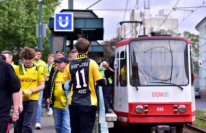 Fans stehen am Bahnsteig einer U-Bahn