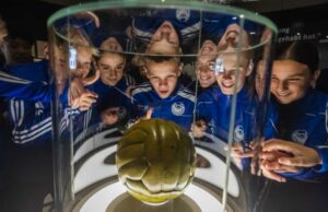 Junge Fußballspieler bewundern Ausstellungsobjekt