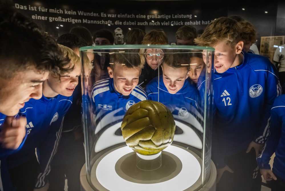 Junge Fußballspieler bewundern Ausstellungsobjekt