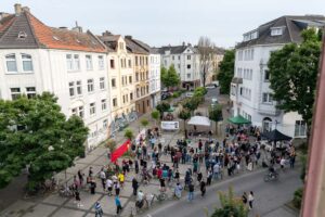 Blick über den Kurt-Piehl-Platz in Dortmund, auf dem sich zahlreiche Menschen zum gemeinsamen Gedenken an Mouhamed Lamine Dramé versammelt haben.