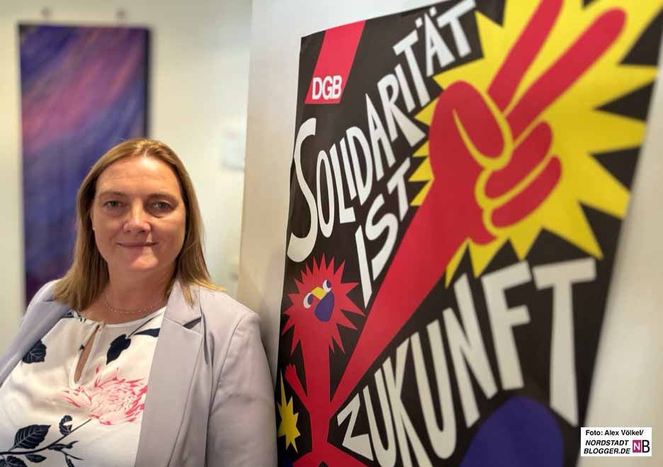 Sie steht vor einem Plakat mit der Botschaft: Solidarität ist Zukunft