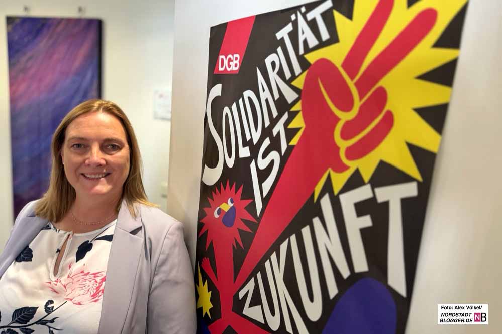 Sie steht vor einem Plakat mit der Botschaft: Solidarität ist Zukunft