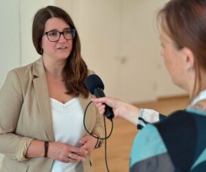 Eine Frau spricht in ein Mikrofon