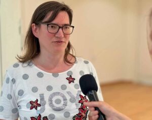 Frau mit Brille spricht in ein Mikrofon