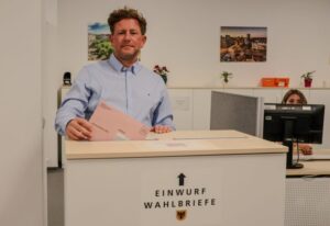 Marc Rostohar wirft einen Wahlbrief in eine Urne.