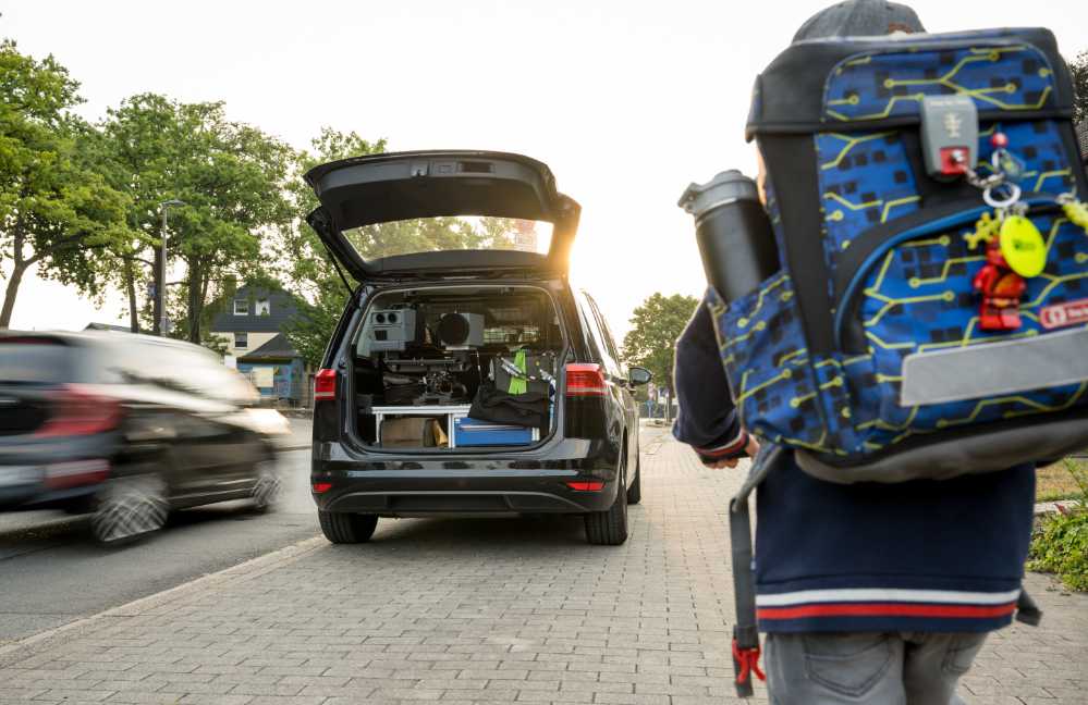 Kind auf dem Schulweg an einer befahrenen Straße