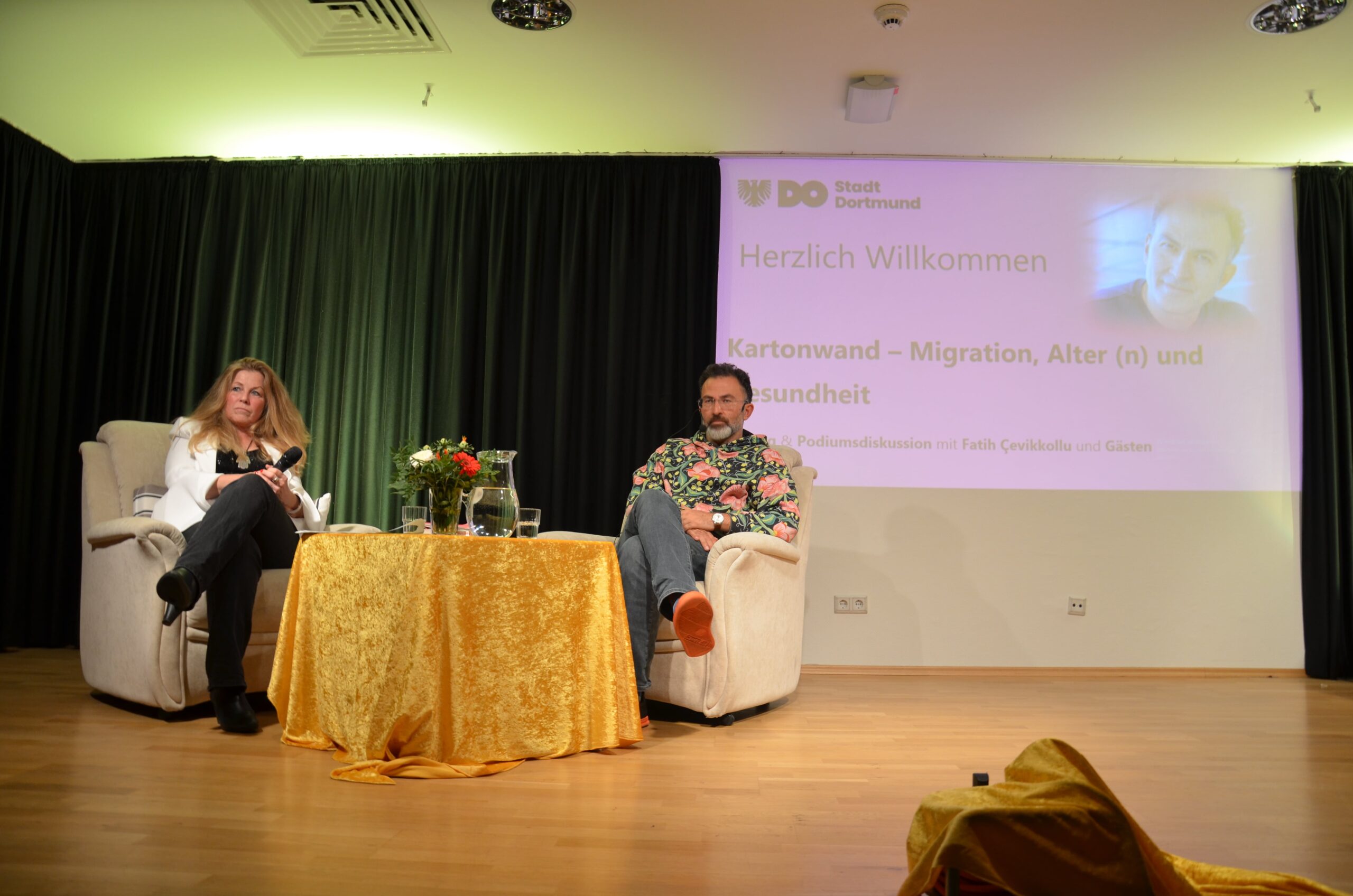 Fatih Çevikkollu gemeinsam mit Moderatorin Dr. Vera Gerling auf der Bühne.