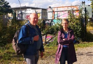 Links ein Mann mit Rucksack, rechts eine Frau