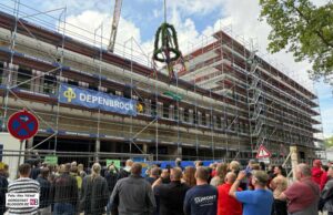 Schaulustige vor dem Baukomplex an der Burgholzstraße 150 schauen sich den Richtkranz an.