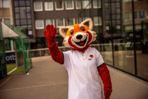 Person im Roter Pander Kostüm