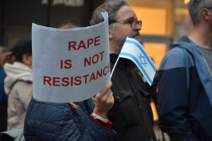 Schild auf der Kundgebung, auf dem „Rape is not Resistance“ steht. 