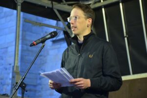 Micha Neumann auf der Bühne, während er seine Rede hält.
