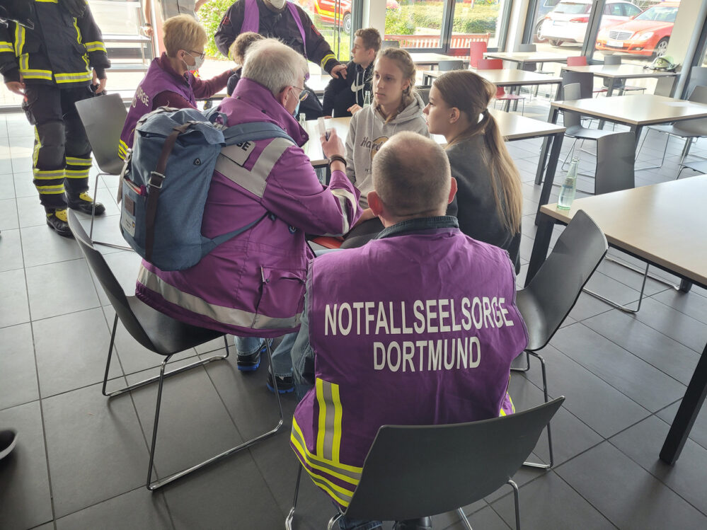 Notfallseelsorger:innen im Gespräch mit Jugendlichen.