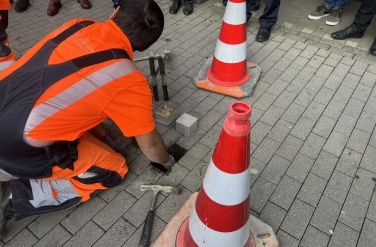 Stolperstein wird von dem Dortmunder Tiefbau in den Gehweg versetzt