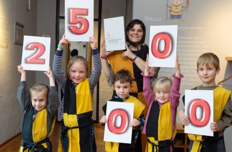 Kindergartengruppe hält Zahlentafeln mit der Rekordzahl hoch