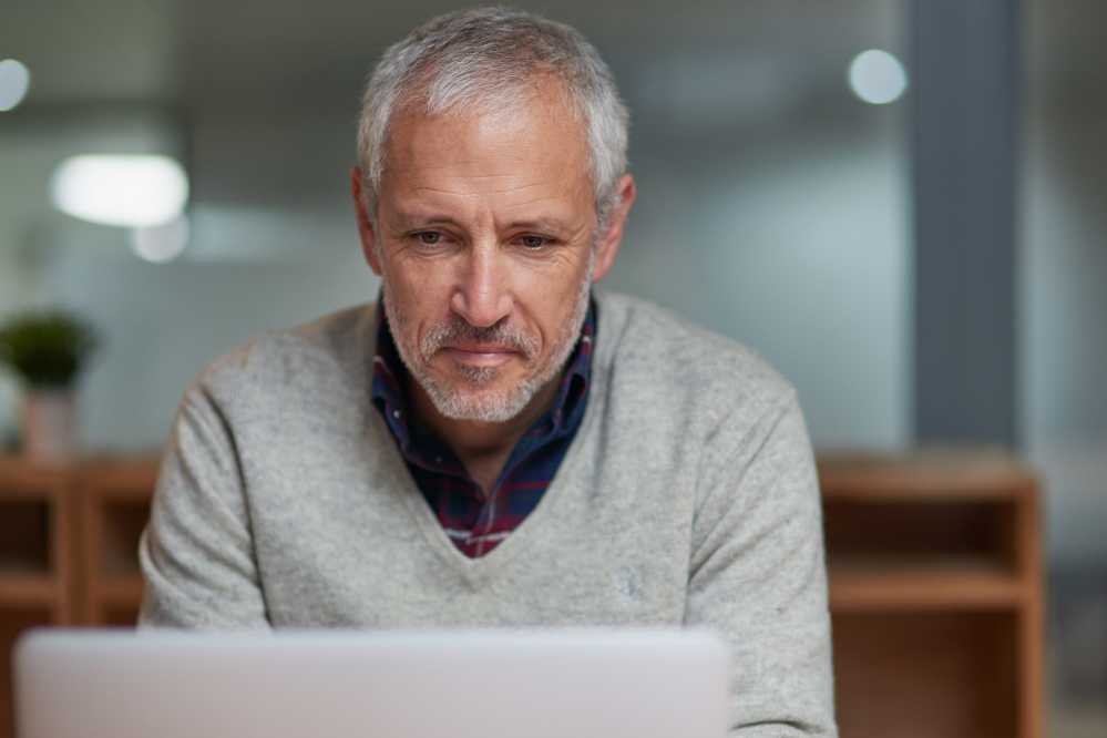 Mann informiert sich an seinem Laptop