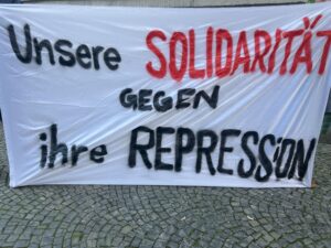 Banner mit der Aufschrift „Unsere Solidarität gegen ihre Repression“.
