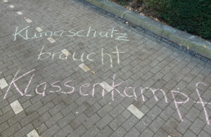 „Klimaschutz braucht Klassenkampf“ mit Kreide geschrieben.