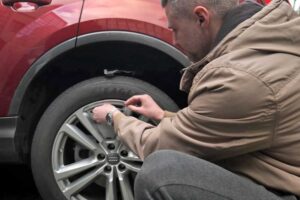 Person beim Radkappenwechsel 