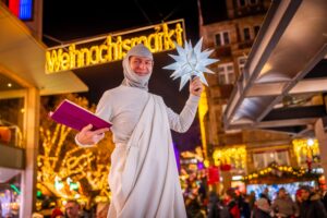 Der drei Meter hohe Stelzenmann Thomas Wachsmann auf dem Weihnachtsmarkt.