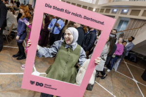 Eine Frau posiert mit einem Rahmen der die Aufschrift: Die Stadt für mich. Dortmund. trägt