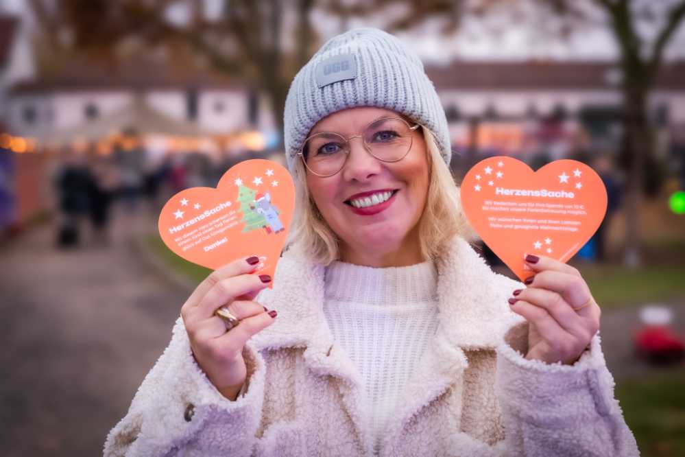 Eine Frau präsentiert die symbolischen Spenden-Herzen