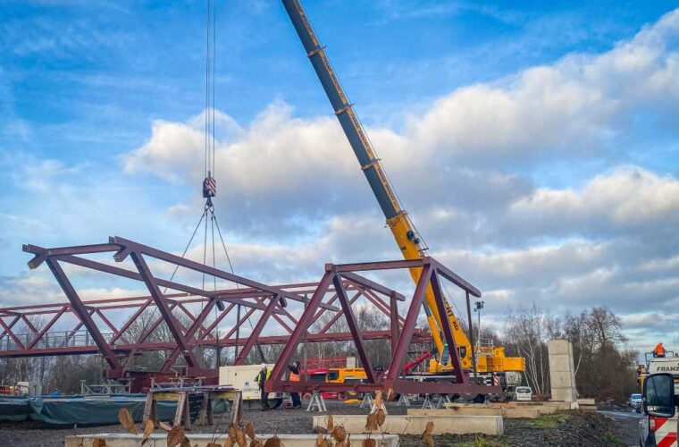 Kran hebt die letzten Brückenteile ein