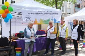 Vier Frauen stehen vor einem Stand der Omas gegen Rechts