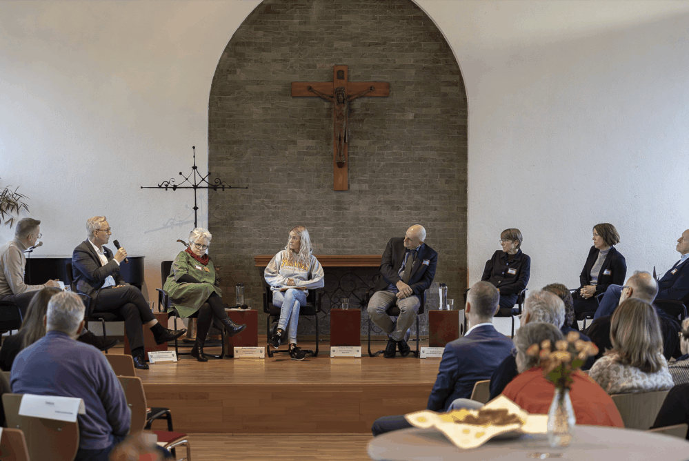 Blick auf das Podium, während die Expert:innen diskutieren.